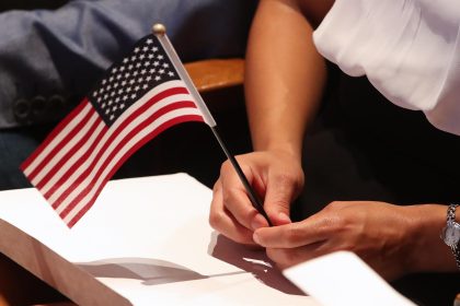 Fotografía de archivo que muestra a una nueva ciudadana de los Estados Unidos sosteniendo la bandera nacional durante un acto de naturalización en Salt Lake City, Utah. EFE/George Frey