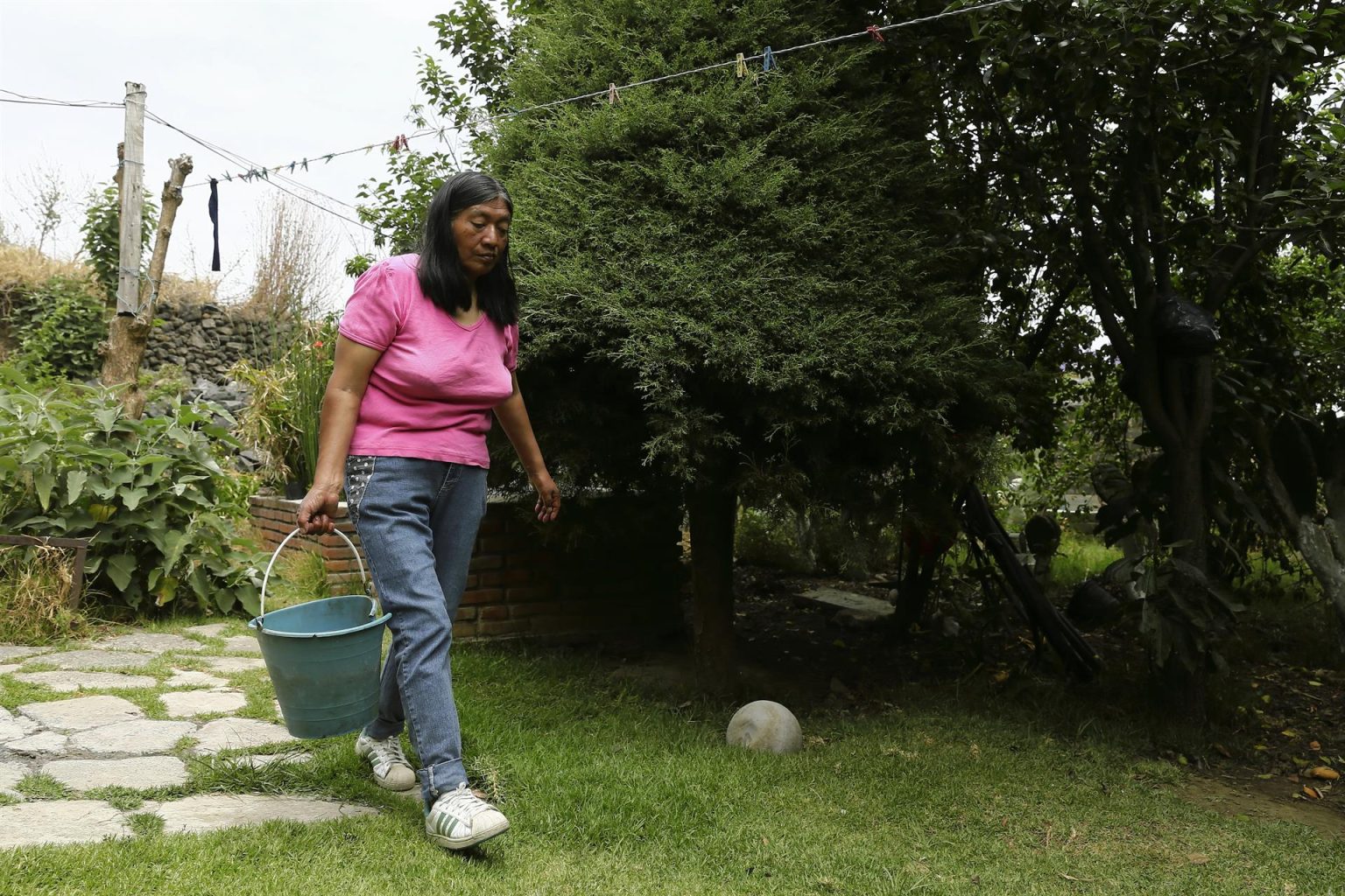 Fotografía de archivo de una habitante de la comunidad de Quiltepec, en la delegación Tlalpan de la Ciudad de México (México), quien utiliza agua reciclada para el riego de sus plantas. EFE/José Méndez