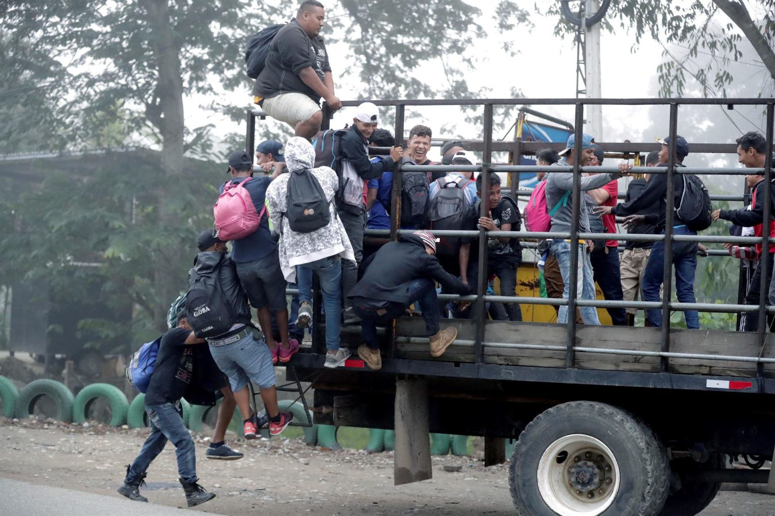 Migrantes hondureños montan en un camión, tras partir la Gran Central Metropolitana de la ciudad de San Pedro Sula, formando una segunda caravana migrante con dirección a EEUU, en el municipio de Quimista (Honduras). Imagen de archivo. EFE/ Gustavo Amador