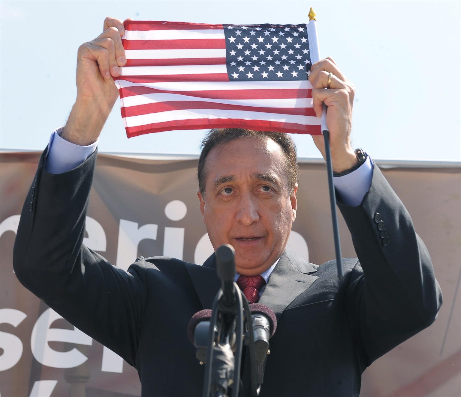 Fotografía de archivo fechada el 9 de abril 2014, que muestra al exsecretario de vivienda, Henry Cisneros, mientras muestra una bandera estadounidense durante su intervención en la explanada frente al Capitolio en Washington (EEUU). EFE/ Lenin Nolly