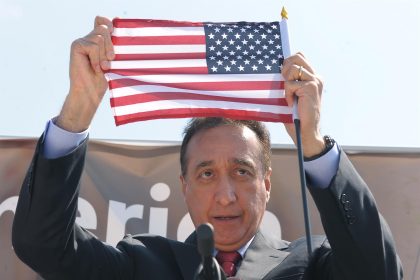 Fotografía de archivo fechada el 9 de abril 2014, que muestra al exsecretario de vivienda, Henry Cisneros, mientras muestra una bandera estadounidense durante su intervención en la explanada frente al Capitolio en Washington (EEUU). EFE/ Lenin Nolly