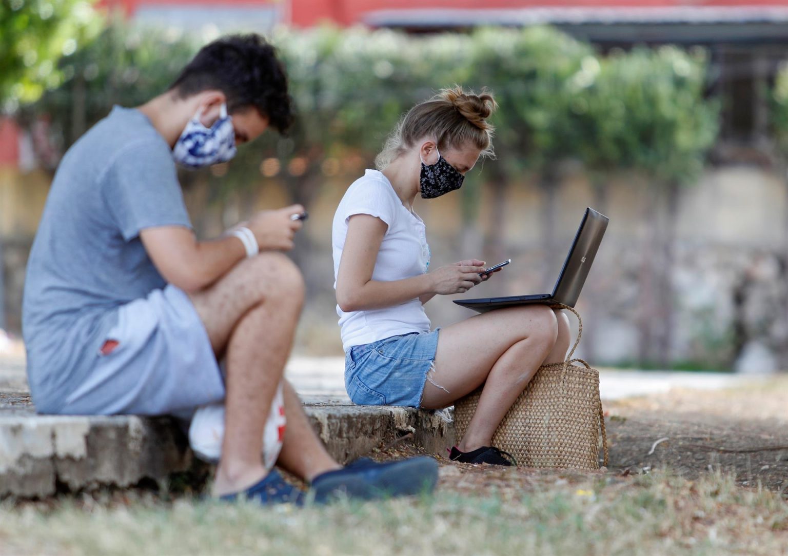 Dos jóvenes son vistos conectados a internet desde un parque con conexión wifi en La Habana (Cuba). EFE/Yander Zamora