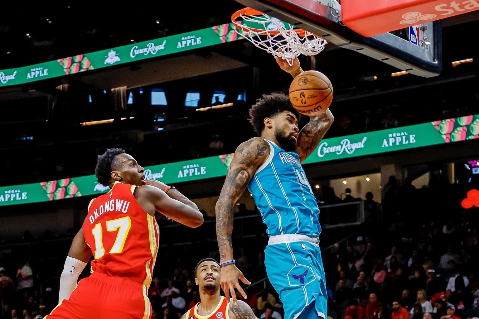 Nick Richards (d), alero de los Hornets de Charlotte, fue registrado este domingo al clavar  un balón en el aro que defienden los Hawks de Atlanta, durante un partido dela NBA, en el estadio Farm Arena, en Atlanta (Georgia, EE.UU.). EFE/Erik S. Lesser