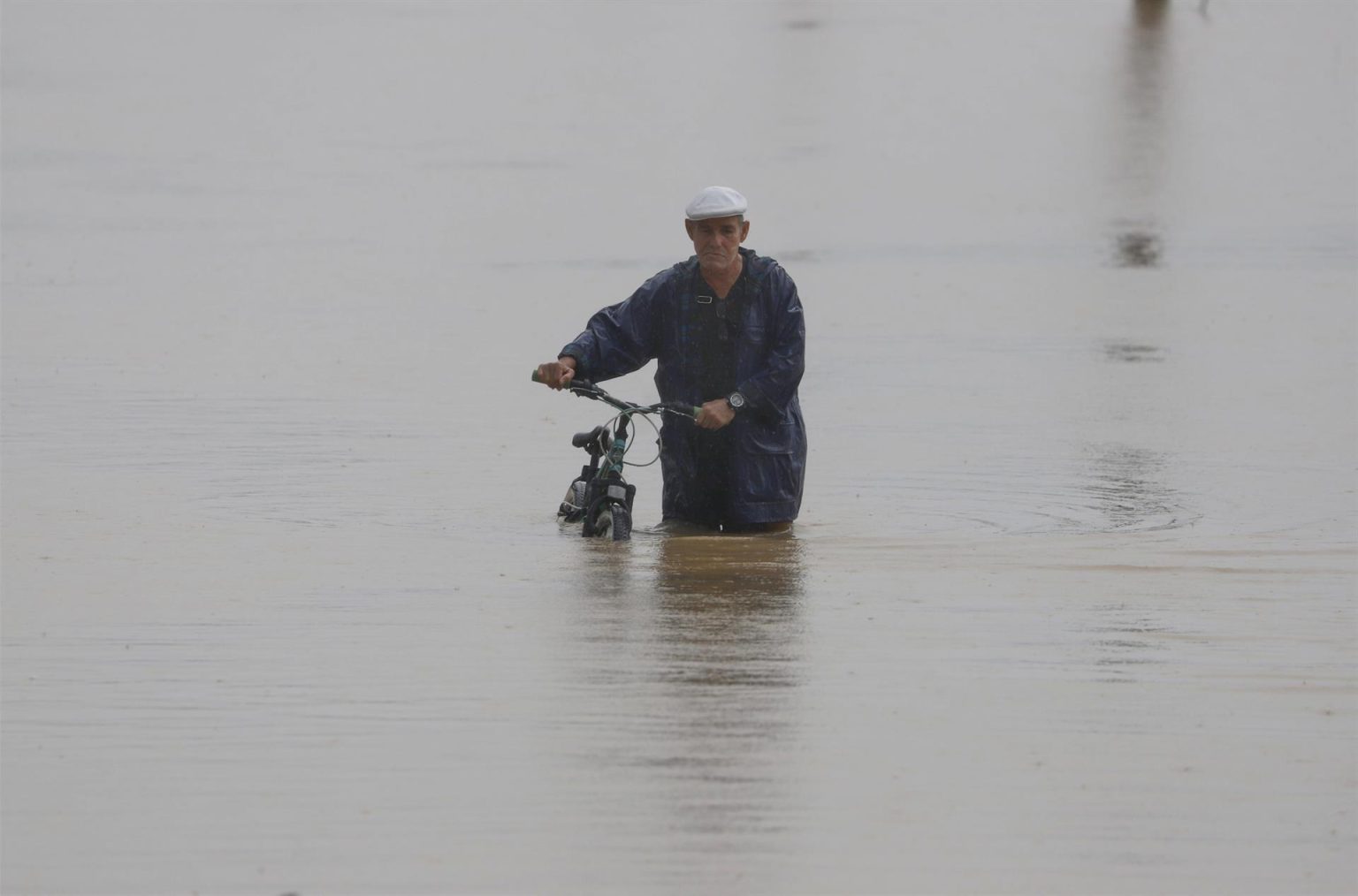 Un hombre cruza con su bicicleta una calle inundada debido a lluvias por el paso del huracán Fiona en Toa Baja (Puerto Rico). Imagen de archivo. EFE/Thais LLorca
