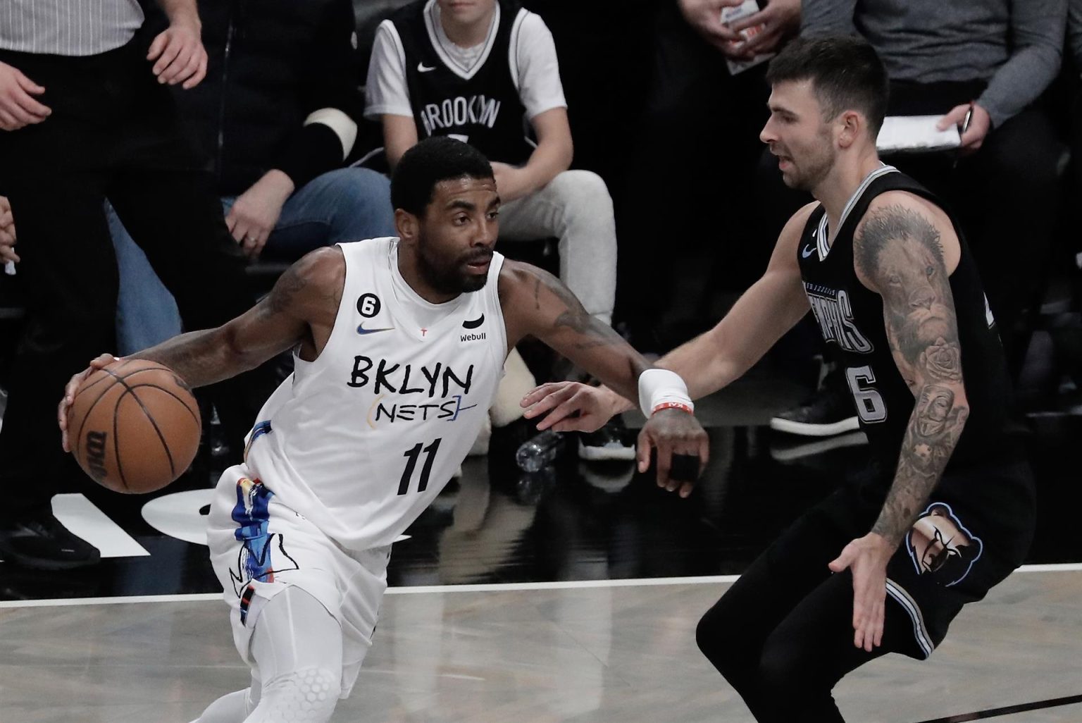 El base de los Brooklyn Nets, Kyrie Irving (i) es defendido por el base de los Memphis Grizzlies, John Konchar (d) durante la primera mitad del partido de baloncesto de la NBA. EFE/EPA/Peter Foley