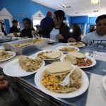 Migrantes reciben hoy alimentos en un campamento junto al Río Bravo con motivo del día de Acción de Gracias, en Ciudad Juárez, estado de Chihuahua (México). EFE/Luis Torres