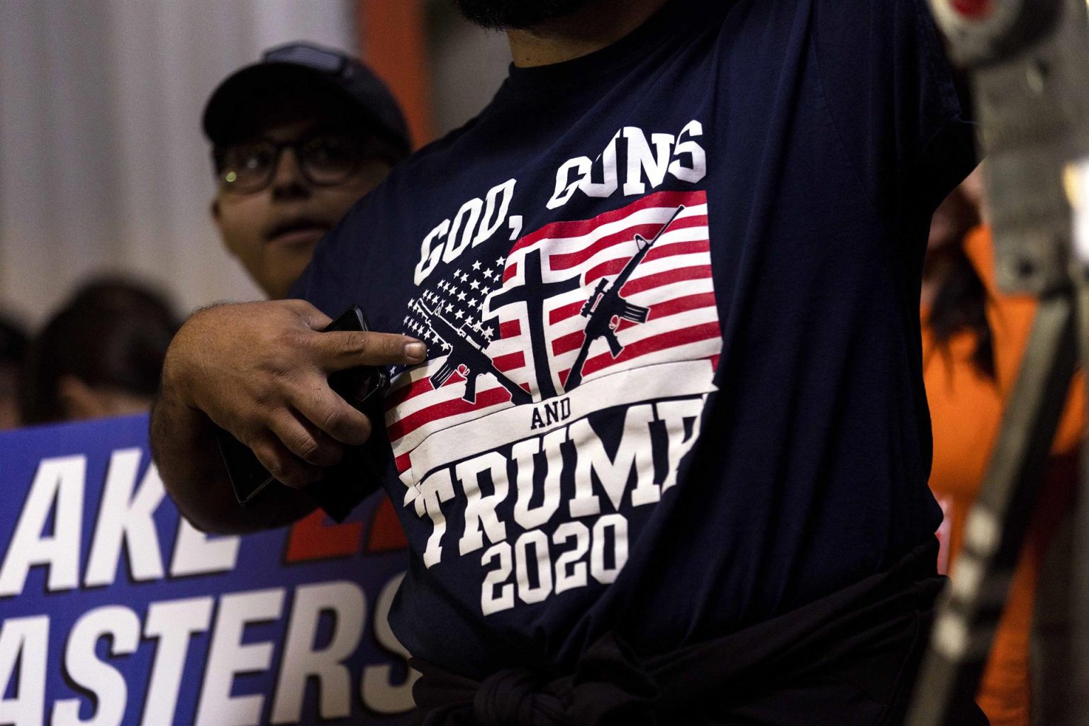 Fotografía de archivo del 06 noviembre donde aparece un simpatizante republicano mientras señala a su camiseta que dice "Dios, armas y Trump 2020", durante un mitin de republicanos en Schnepf Farms en Queen Creek, Arizona (EEUU). EFE/Etienne Laurent