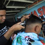 El migrante de origen venezolano, José Miguel Ceballos, corta el cabello a una persona el 11 de noviembre de 2022 en Ciudad Juárez, Chihuahua (México). EFE/Luis Torres