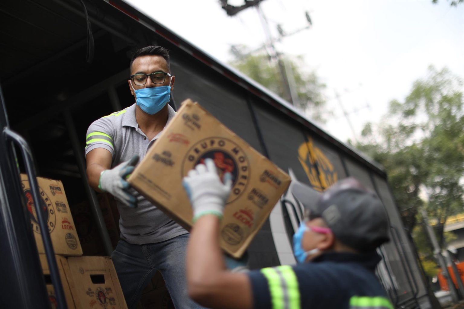 Dos trabajadores descargan cajas de cerveza en la Ciudad de México. Imagen de archivo. EFE/ Sáshenka Gutiérrez