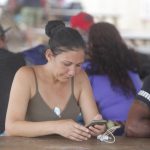 Una mujer es vista usando su celular en un campamento de migrantes procedentes de diversos países en Darién (Panamá). EFE/ Carlos Lemos