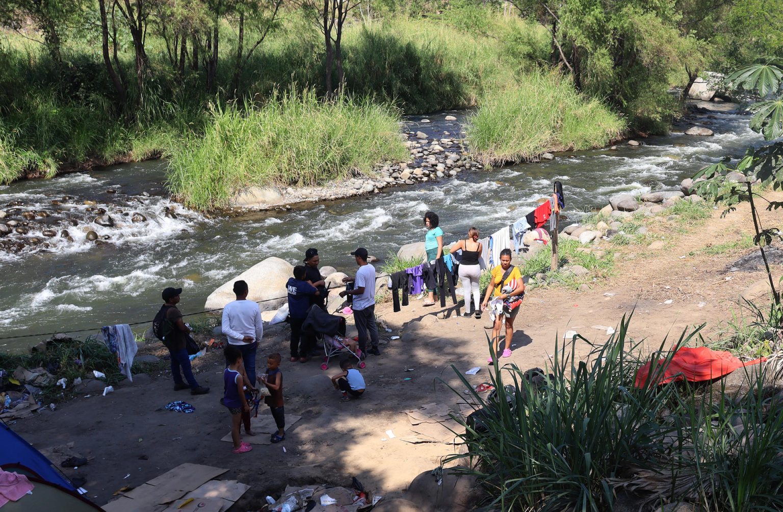 Grupos de personas migrantes se establecen en un campamento improvisado a orillas del Río Coatán hoy, en la ciudad de Tapachula, estado de Chiapas (México). EFE/ Juan Manuel Blanco