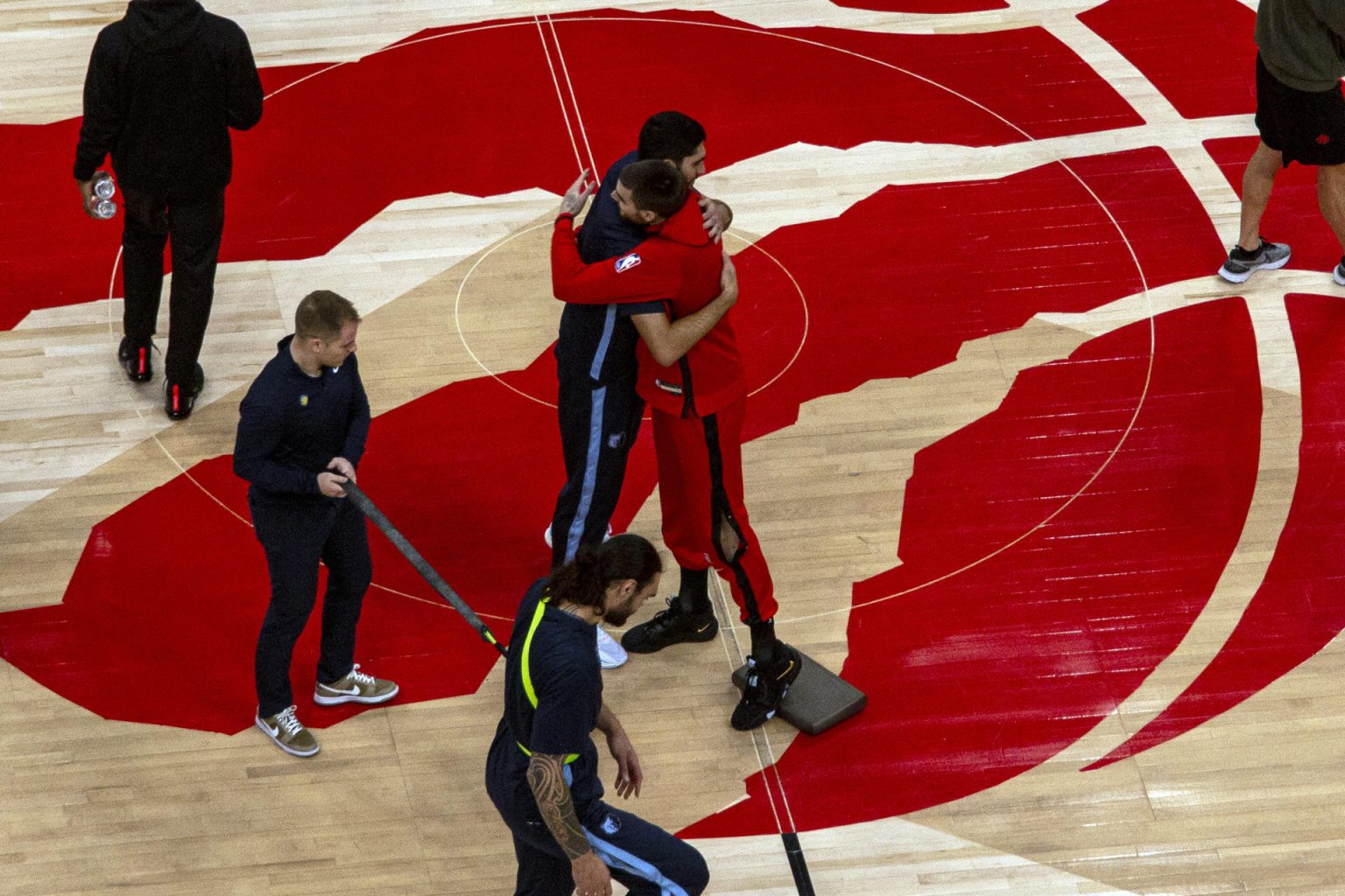 Santi Aldama (i) y Juancho Hernangómez (d) se saludan poco antes del inicio del partido entre los Raptors y los Grizzlies hoy, en Toronto (Canadá). EFE/Julio César Rivas