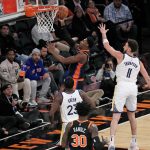 El escolta de los New York Knicks RJ Barrett (c) dispara sobre los defensores de los Golden State Warriors. EFE/EPA/Peter Foley