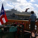 Fotografía de archivo que muestra a dos turistas paseando frente a un crucero en el Puerto de San Juan. EFE/Thais Llorca