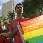 Un joven sostiene una bandera del arcoíris durante una protesta. Imagen de archivo. EFE/Santi Donaire