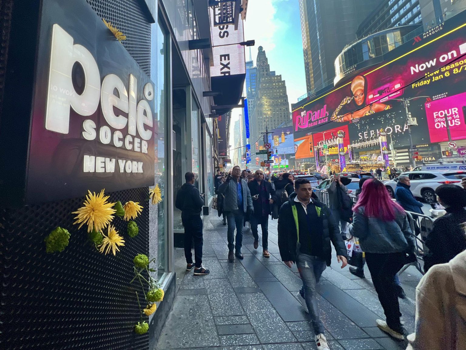 Un hombre pasa delante de unas flores colgadas hoy, en la entrada de la tienda Pelé Soccer situada en la icónica plaza de Times Square, en Nueva York (EEUU). EFE/ Sarah Yáñez-Richards