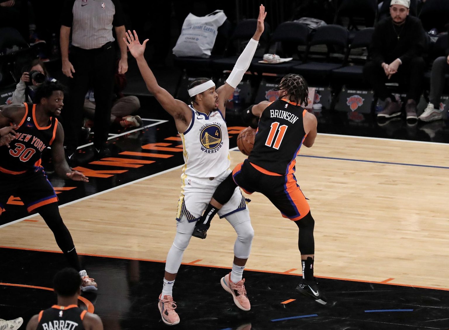 El escolta de los New York Knicks Jalen Brunson (d) es defendido por el escolta de los Golden State Warriors Moses Moody (c). EFE/EPA/Peter Foley