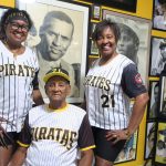 Fotografía que muestra las hijas de Justino Clemente Walker, Judith (i) y Janet Clemente (d), mientras abrazan a su padre en el pequeño museo que tienen dedicado a Roberto Clemente en su residencia, el 23 de diciembre de 2022 en Carolina (Puerto Rico). EFE/Jorge Muñiz