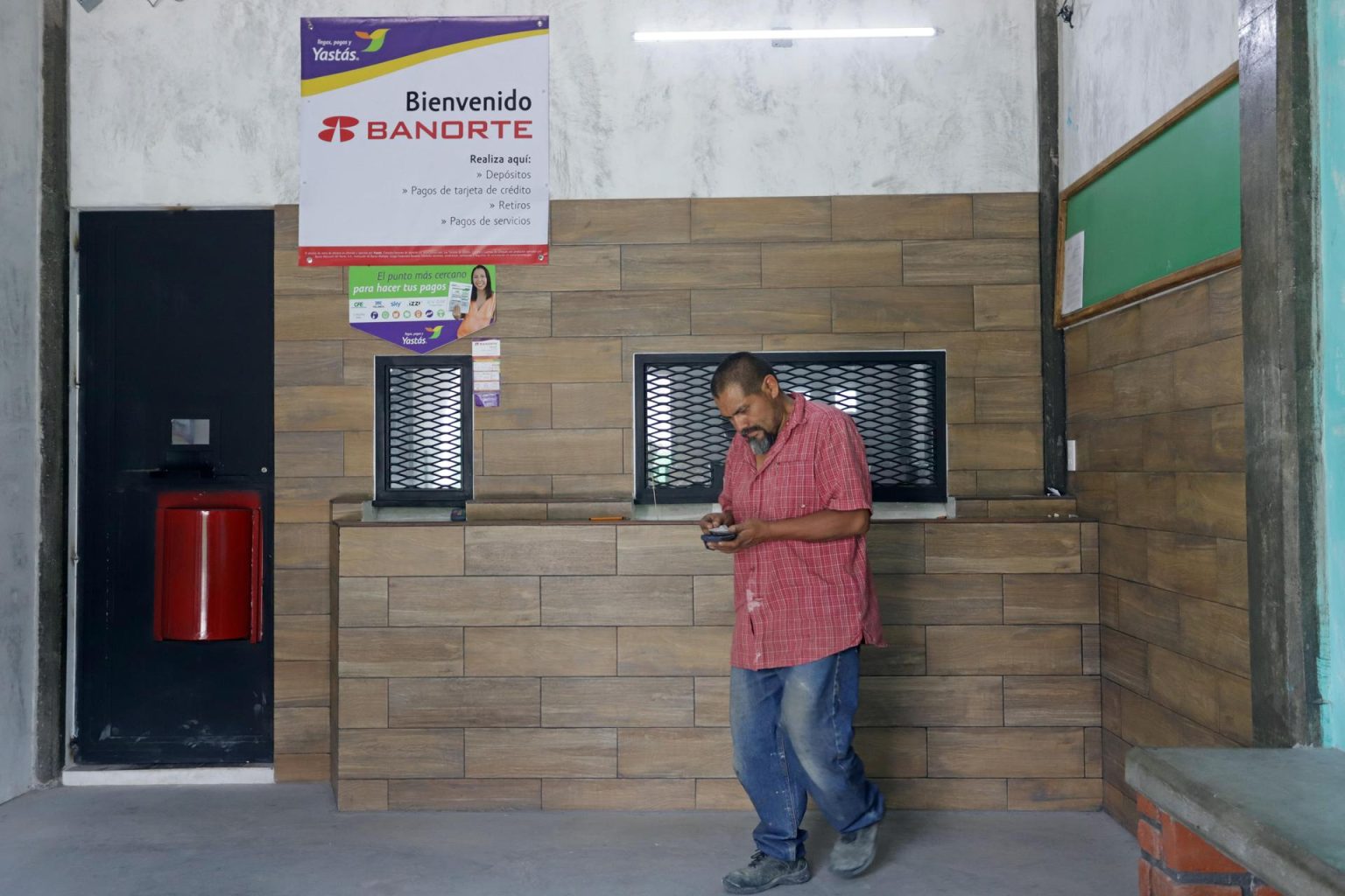 Fotografía de archivo que muestra a un hombre que retira dinero en una casa de cambio de divisas en el municipio de Tepeojuma. EFE/Hilda Ríos