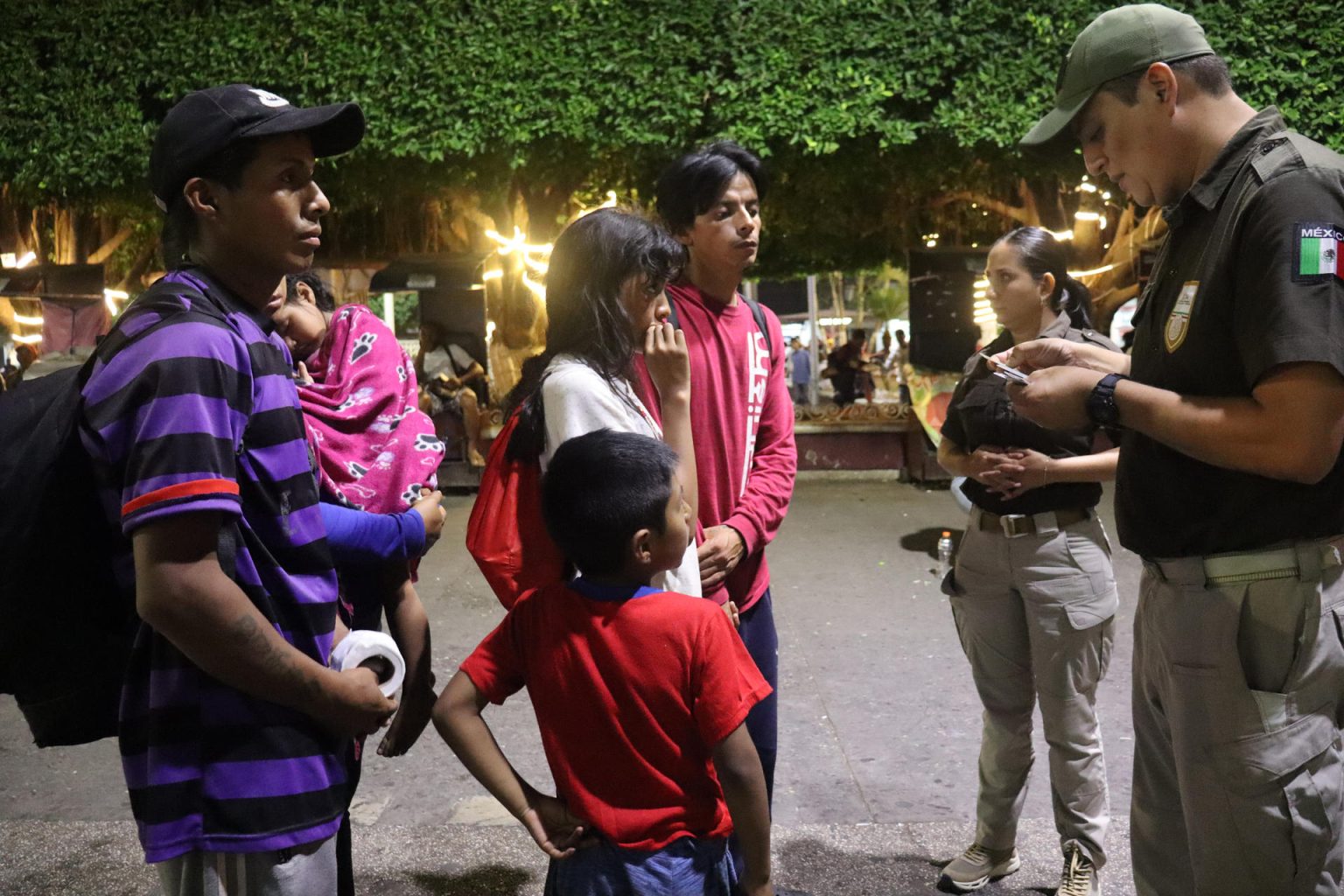 Miembros del Instituto Nacional de Migración (INM) hablan hoy con una familia de migrantes durante un operativo en la ciudad de Tapachula, Chiapas (México). EFE/Juan Manuel Blanco