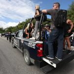 Policías estatales trasladan turistas en sus vehículos hacia el Aeropuerto Internacional de Cancún (México). EFE/Alonso Cupul