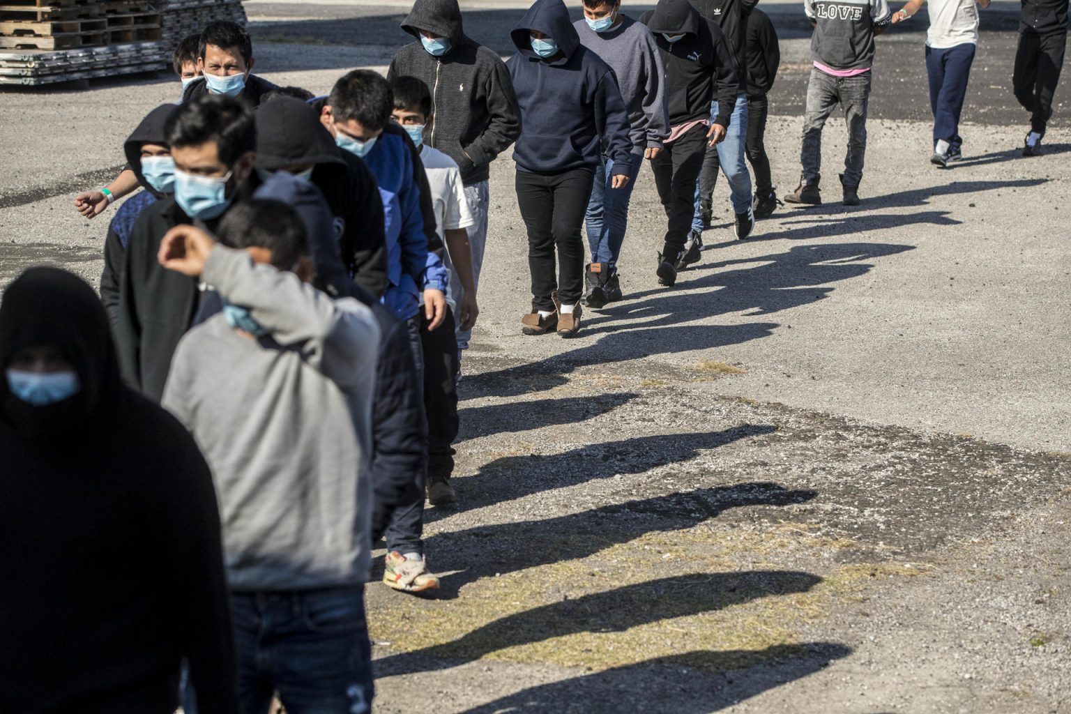 Un grupo de personas deportadas caminan hoy, provenientes del primer vuelo desde los Estados Unidos a Guatemala, en la Fuerza Aérea Guatemalteca, en Cuidad de Guatemala (Guatemala). EFE/ Esteban Biba