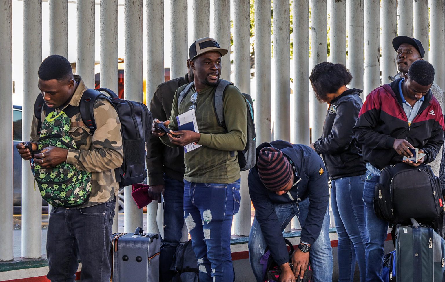 Grupos de migrantes hacen fila para cruzar a Estados Unidos y continuar con su proceso de asilo a través de la garita internacional del Chaparral en la fronteriza Tijuana (México). Imagen de archivo. EFE/Joebeth Terriquez