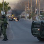 Un vehículo de pasajeros calcinado se observa este jueves tras los enfrentamientos de fuerzas federales con grupos armados hoy, en la ciudad de Culiacán, estado de Sinaloa (México). EFE/Juan Carlos Cruz