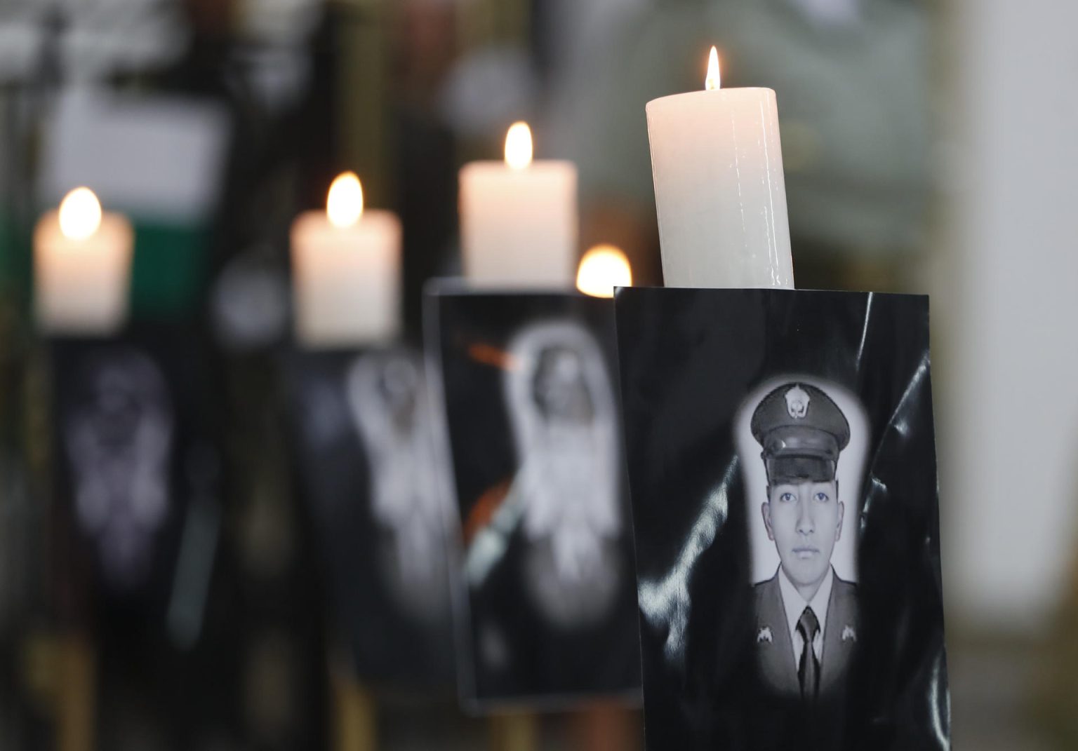 Fotografía de archivo de retratos durante una ceremonia religiosa en honor a los policías asesinados recientemente en el país por el Clan del Golfo, en Cali (Colombia). EFE/ Ernesto Guzmán Jr