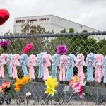 Fotografía de archivo de varias personas que depositan flores y juguetes en un monumento a las víctimas del tiroteo en el instituto de Parkland, Florida, (Estados Unidos). EFE/ Cristobal Herrera