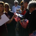 Un mujer recoge el certificado de su ciudadanía y la bandera estadounidense. Imagen de archivo. EFE/Thais Llorca