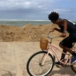 Fotografía de archivo que muestra a un joven que monta bicicleta mientras observa las altas olas en San Juan, Puerto Rico. Inicio de archivo. EFE/Thais Llorca