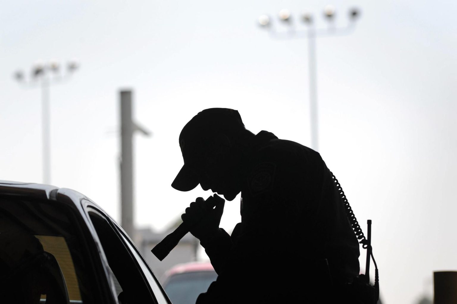 Un agente de la agencia de Aduanas y Protección Fronteriza ilumina este fin con una linterna el interior de un autmovil que pasa por la garita fronteriza de San Ysidro (San Diego) desde Tijuana (Mexico). Imagen de archivo. EFE/DAVID MAUNG