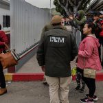 Grupos de personas migrantes hacen fila para cruzar a Estados Unidos y continuar con su proceso de asilo a través de la garita internacional del Chaparral ayer, en Tijuana, Baja California (México). EFE/ Joebeth Terríquez