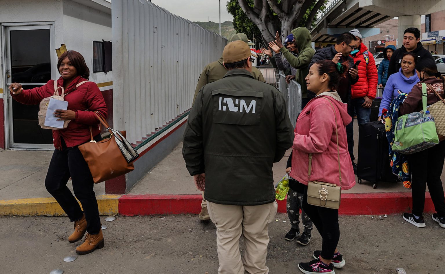 Grupos de personas migrantes hacen fila para cruzar a Estados Unidos y continuar con su proceso de asilo a través de la garita internacional del Chaparral ayer, en Tijuana, Baja California (México). EFE/ Joebeth Terríquez