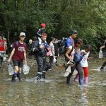 Fotografía de archivo de migrantes que atraviesan un río con la intención de llegar a Panamá, el 8 de octubre de 2022, a través del Tapón del Darién (Colombia). EFE/ Mauricio Dueñas Castañeda