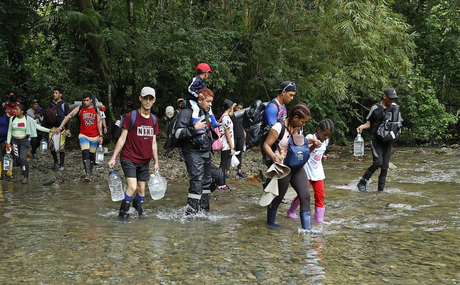 Fotografía de archivo de migrantes que atraviesan un río con la intención de llegar a Panamá, el 8 de octubre de 2022, a través del Tapón del Darién (Colombia). EFE/ Mauricio Dueñas Castañeda