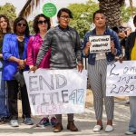 Unas personas sostienen pancartas y carteles que piden poner fin al Título 42 en San Diego, California. EFE/Manuel Ocaño