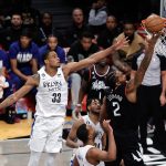 El alero de LA Clippers, Kawhi Leonard (D), lanza un tiro que pasa al centro defensor de los Nets de Brooklyn, Nic Claxton (I), y sus compañeros en la segunda mitad del partido de la NBA entre Los Angeles Clippers y los Brooklyn Nets en el Barclays Center de Brooklyn, Nueva York, EE.UU. EFE/EPA/JASON SZENES