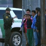 Un agente de la patrulla fronteriza estadounidense habla a un grupo de jóvenes migrantes centroamericanos tras ser detenidos en los margenes del Rio Bravo, en la fronteriza Ciudad Juárez (México). Imagen de archivo. EFE/Rey R. Jauregui