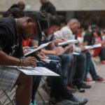 Migrantes llenan solicitudes de trabajo durante la inauguración de una feria del empleo en la ciudad de Tijuana, en el estado de Baja California (México). EFE/Joebeth Terriquez