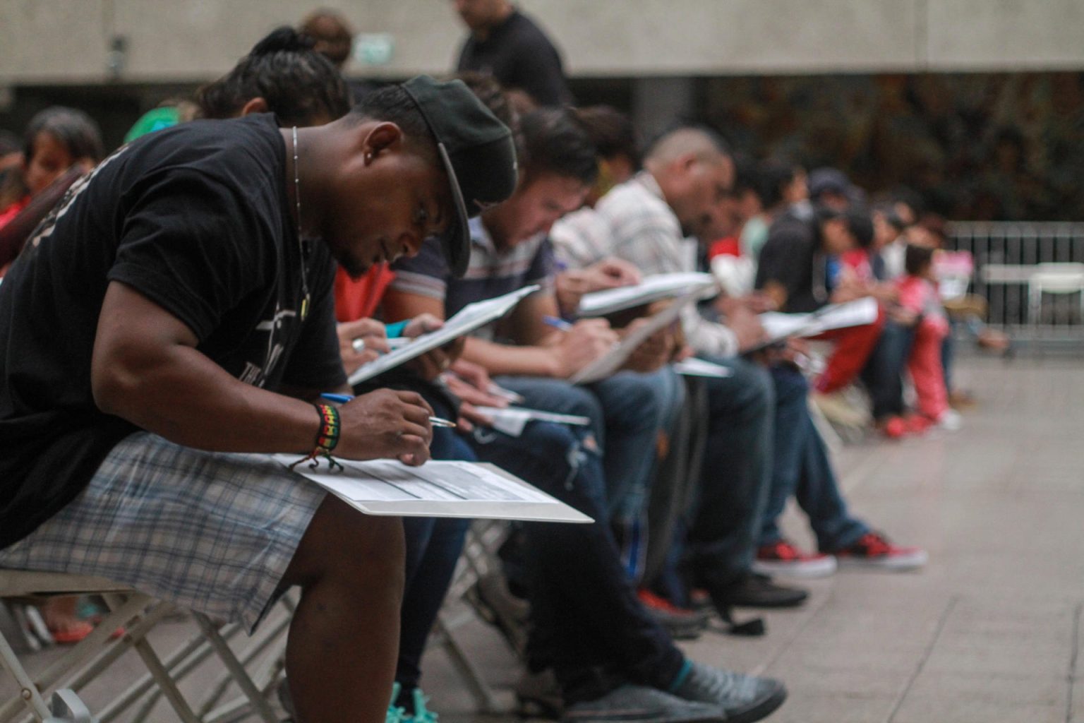 Migrantes llenan solicitudes de trabajo durante la inauguración de una feria del empleo en la ciudad de Tijuana, en el estado de Baja California (México). EFE/Joebeth Terriquez