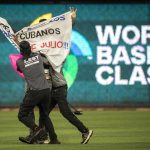 Un manifestante fue registrado este domingo, 19 de marzo, al ser detenido, luego de ingresar al campo de juego con una pancarta en contra del Gobierno de Cuba, durante una de las semifinales del Clásico Mundial de Béisbol disputada entre Estados Unidos y Cuba, en el estadio LoanDepot Park, en Miami (Florida, EE.UU.). EFE/Cristóbal Herrera