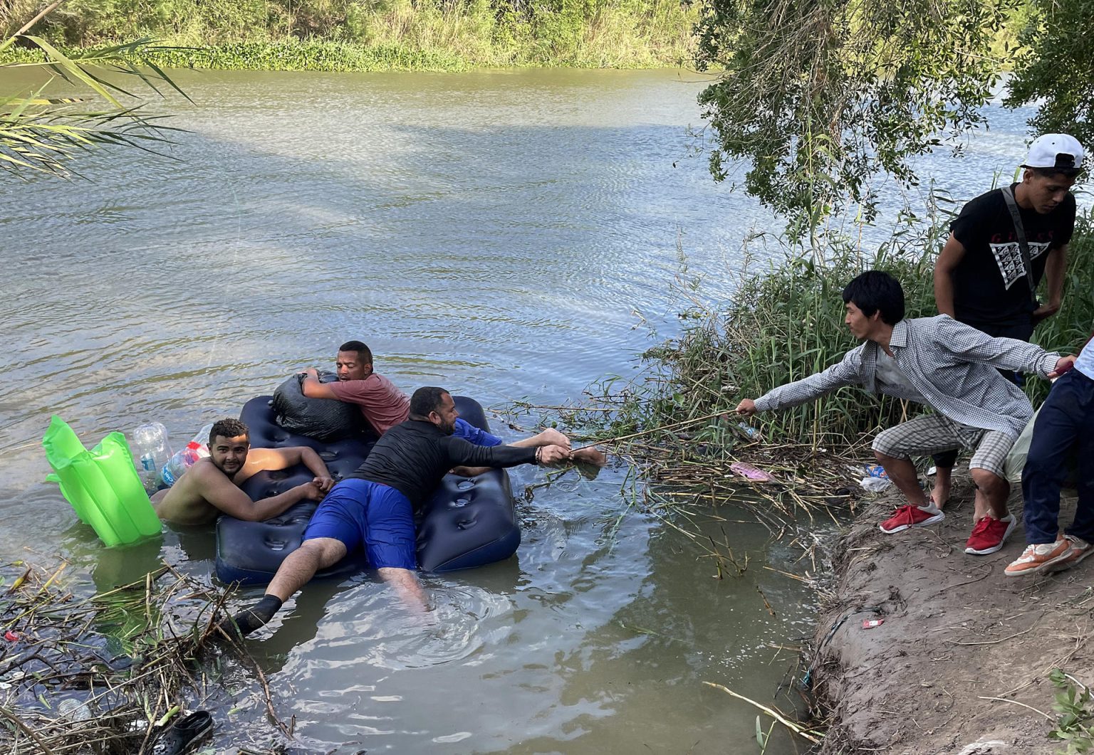 Un grupo de migrantes, ayudados de un inflable, intentan cruzar el Río Bravo el 11 de abril de 2023, en la ciudad de Matamoros en Tamaulipas (México). EFE/Abraham Pineda Jácome