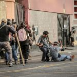 Fotógrafos y miembros de la prensa se protegen mientras cubren las confrontaciones entre Policía y manifestantes en el Parque Universitario, durante la llamada "toma de Lima" en Lima (Perú). EFE/ Str