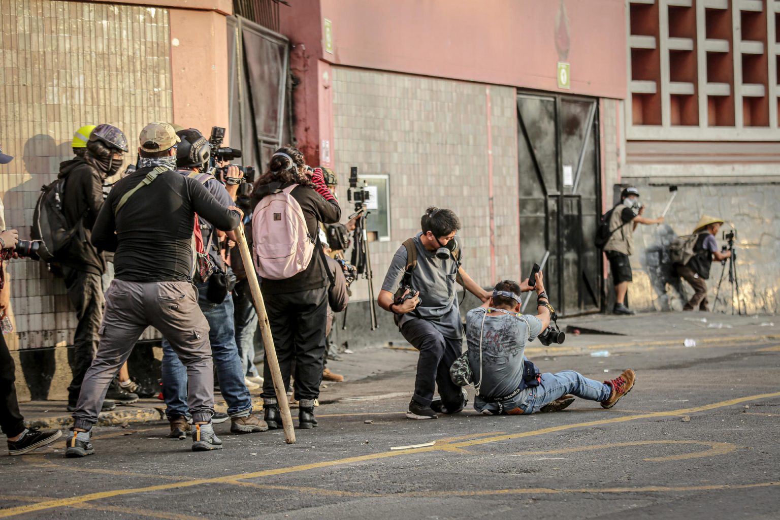 Fotógrafos y miembros de la prensa se protegen mientras cubren las confrontaciones entre Policía y manifestantes en el Parque Universitario, durante la llamada "toma de Lima" en Lima (Perú). EFE/ Str