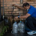 Un hombre recolecta agua potable en unos recipientes en Caracas (Venezuela). Imagen de archivo. EFE/ Miguel Gutiérrez