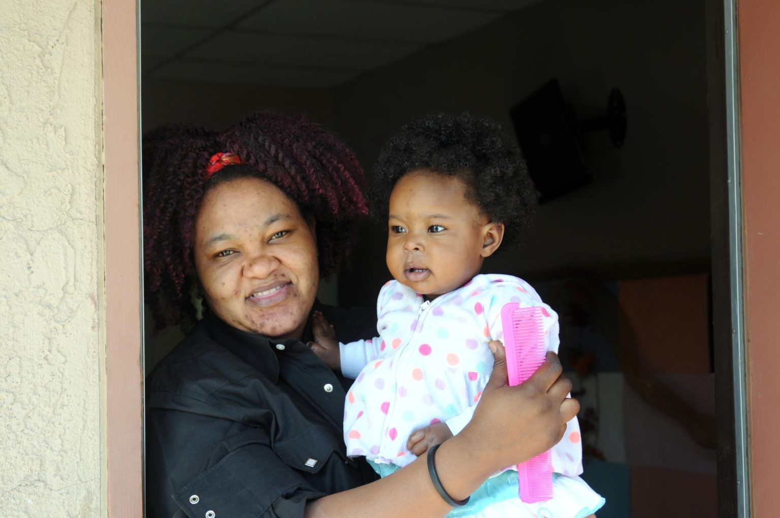 Fotografía de archivo donde aparece Gina, una inmigrante haitiana de 28 años, mientras carga a su hija Mónica de diez meses en la iglesia Monte Vista en Phoenix, Arizona. EFE/Beatriz Limón