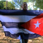 Fotografía de archivo de un hombre indocumentado que sostiene una bandera de Cuba, mientras espera ser deportado a la isla. EFE/Abraham Pineda-Jacome