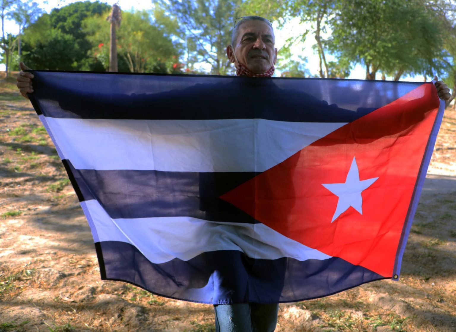 Fotografía de archivo de un hombre indocumentado que sostiene una bandera de Cuba, mientras espera ser deportado a la isla. EFE/Abraham Pineda-Jacome